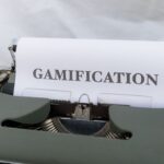 a close up of a typewriter with a paper that reads gamification