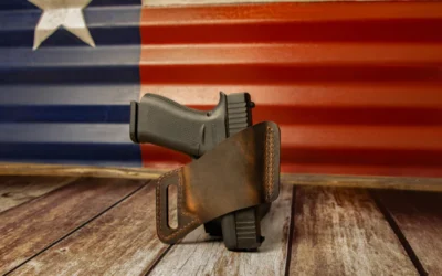 a leather holster on a wooden surface with the american flag in the background
