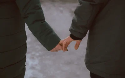 a man and woman holding hands while standing next to each other