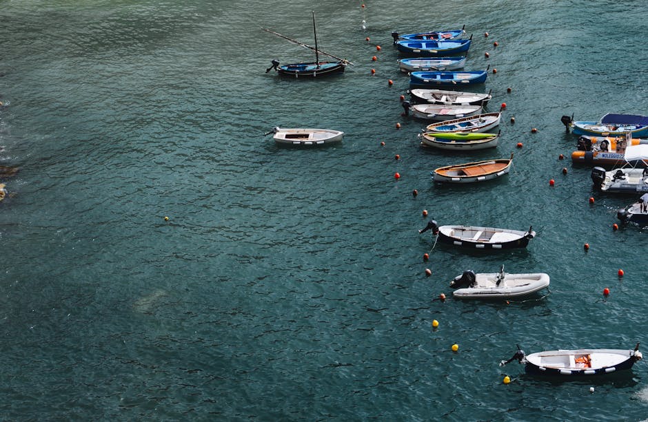 A serene aerial view of various boats anchored in a tranquil harbor with rippling water.