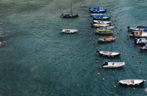 A serene aerial view of various boats anchored in a tranquil harbor with rippling water.