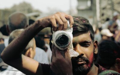A photographer takes a picture during holi festival.