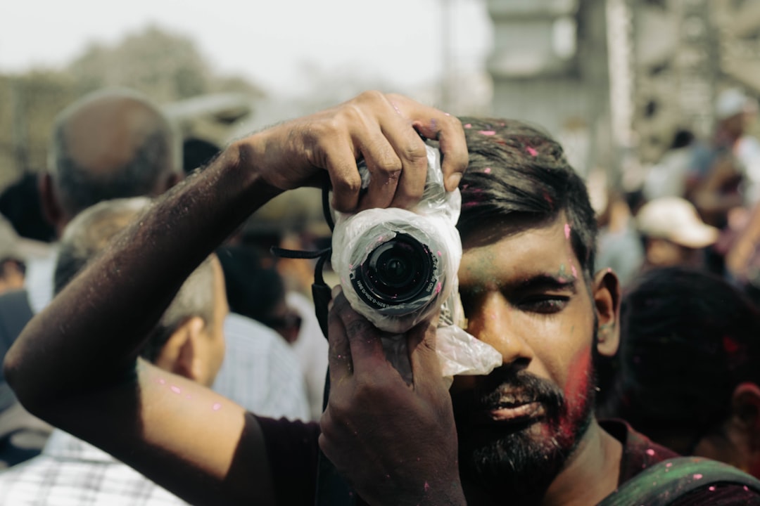 A photographer takes a picture during holi festival.