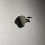 a close up of an apple logo on a silver surface