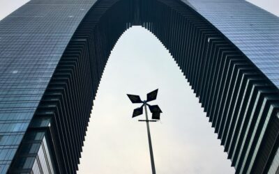 A tall building with a wind indicator in front of it