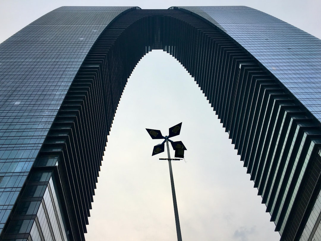 A tall building with a wind indicator in front of it