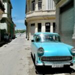 teal vehicle parked beside building