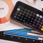 A smartphone displaying a calculator app on financial charts, showcasing revenue analysis.