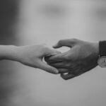 Monochrome image of two hands holding, symbolizing love and connection.