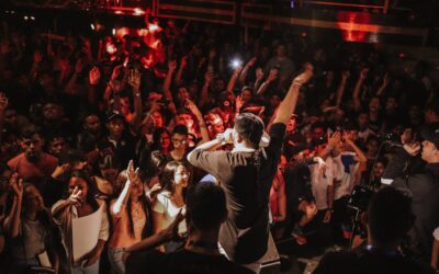 Vibrant rap concert with lively crowd and dynamic stage performance in a bustling nightclub atmosphere.