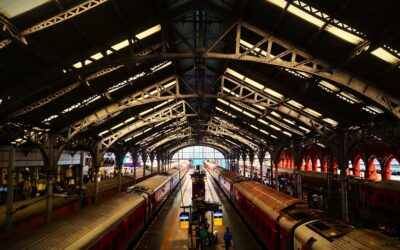 Two trains at a grand, historic train station.