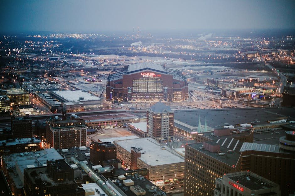 Captivating aerial view of Lucas Oil Stadium and Indianapolis cityscape at dusk.