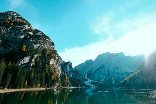 Breathtaking view of mountains and a calm lake reflecting the bright sky. Perfect for nature lovers and travel enthusiasts.