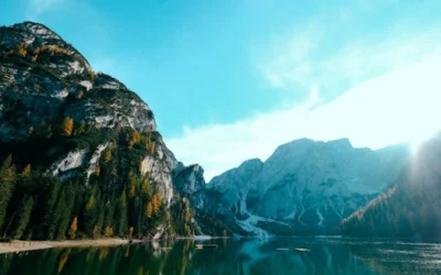 Breathtaking view of mountains and a calm lake reflecting the bright sky. Perfect for nature lovers and travel enthusiasts.