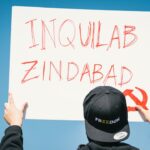 person in black jacket wearing black cap