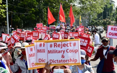 a large group of people holding signs and wearing masks