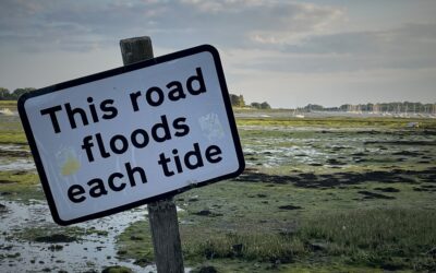 this road floods each tide sign posted on a wooden post