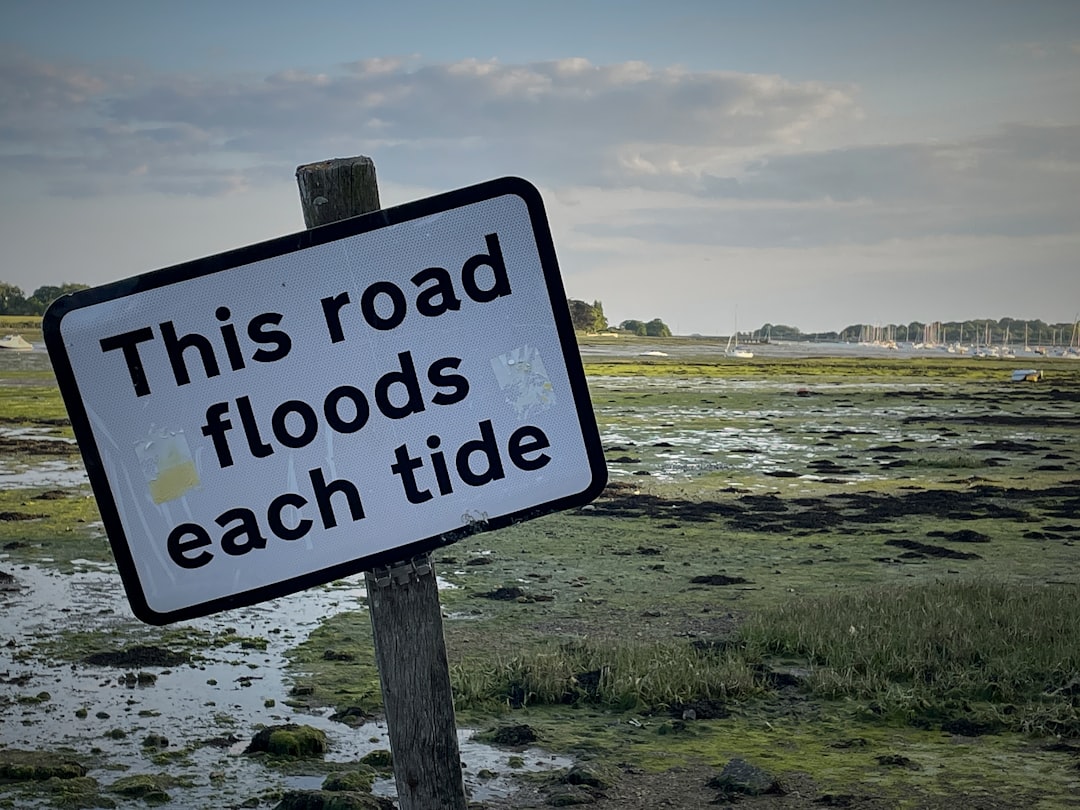 this road floods each tide sign posted on a wooden post