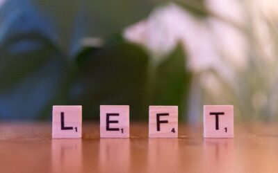 Close-up of wooden Scrabble tiles spelling the word 'LEFT' on a blurred background.