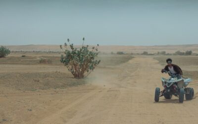 A man riding an atv on a dirt road