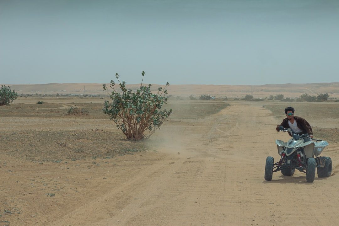 A man riding an atv on a dirt road