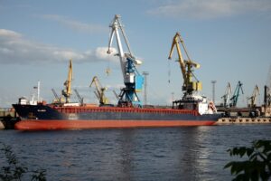 A cargo ship docks at a busy port.