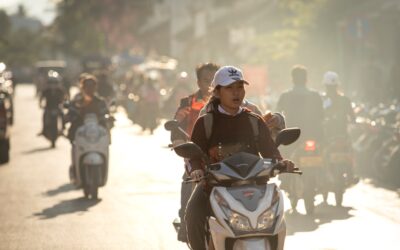 A group of people riding motorcycles down a street