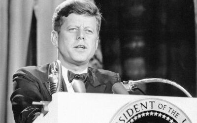 a man in a suit and tie standing at a podium