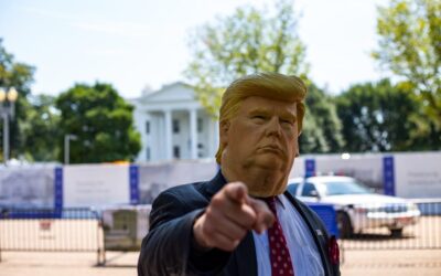 man wearing Donald Trump mask standing in front of White House