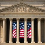 a building with columns and two american flags on it