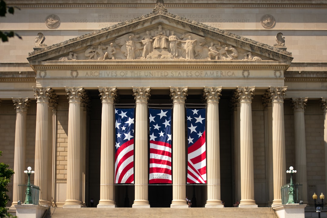 a building with columns and two american flags on it