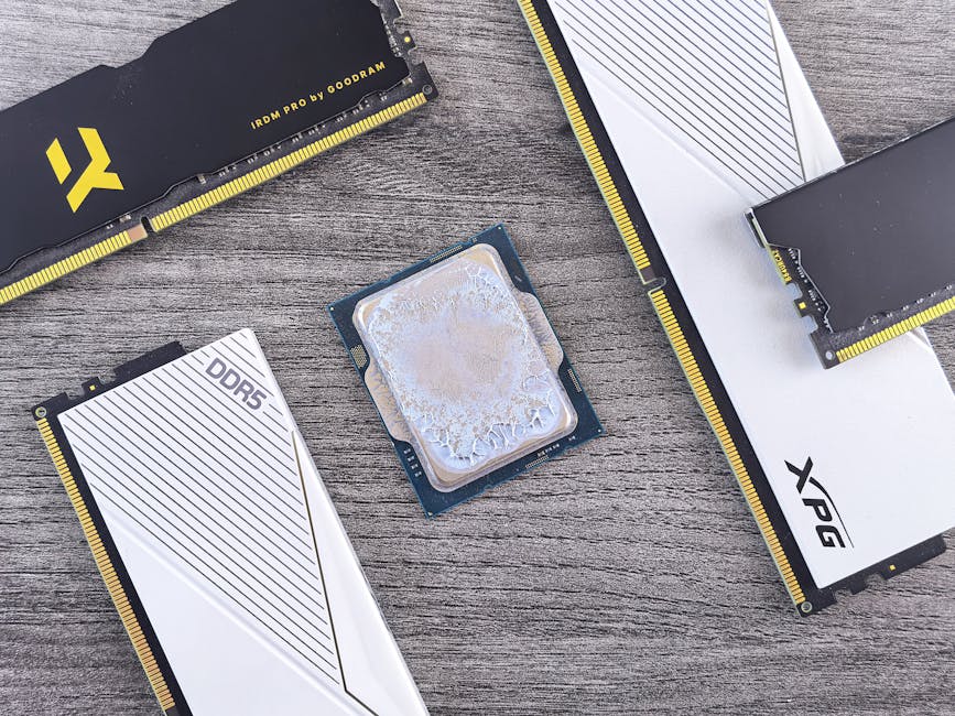 Detailed shot of DDR5 RAM modules and a CPU on a wooden table, highlighting computer hardware.