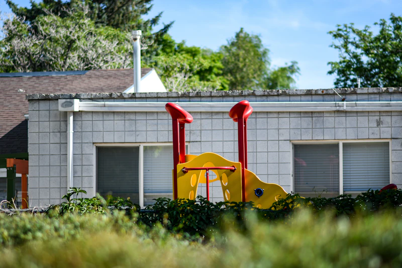 yellow and red plastic toy car on green grass field