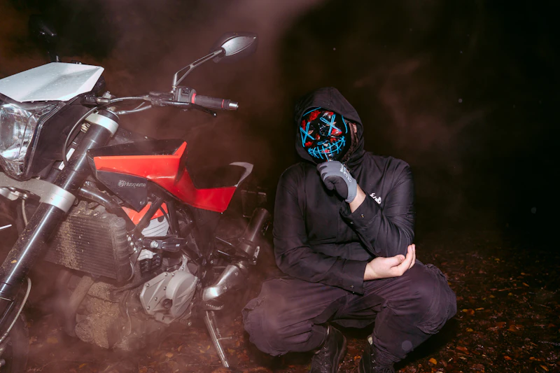 Person in mask and hoodie next to motorcycle