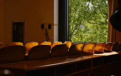 Empty classroom seats overlook a tree.