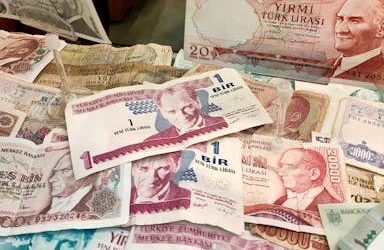 Turkish Lira banknotes of various denominations displayed, showcasing historical currency.