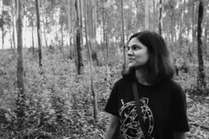 a woman standing in the middle of a forest