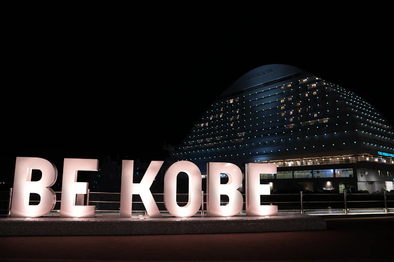 A large sign that says be kobe in front of a building