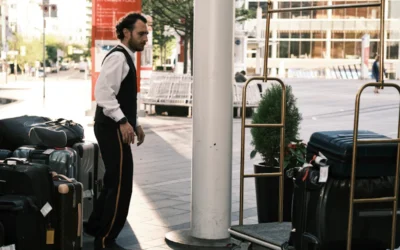 a man standing next to a pile of luggage