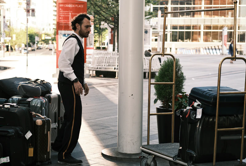 a man standing next to a pile of luggage