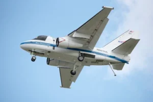 NASA aircraft in flight showcasing engineering marvel against a clear blue sky.