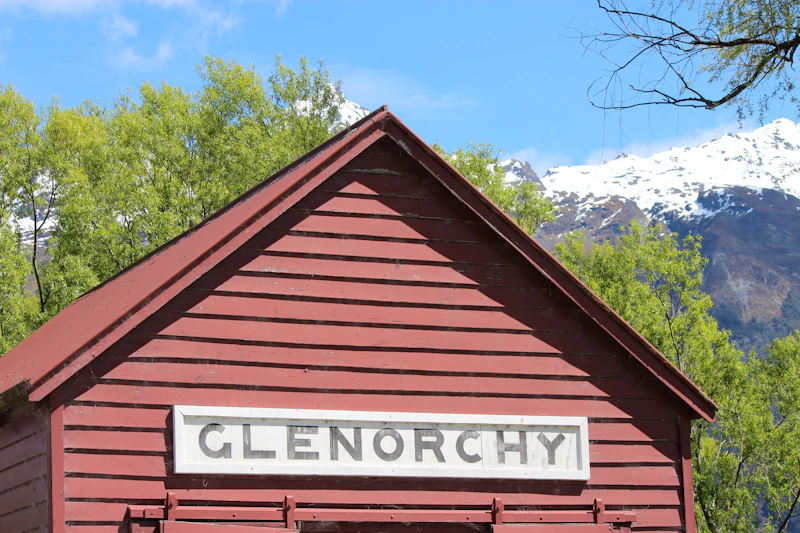 brown wooden house near green trees during daytime