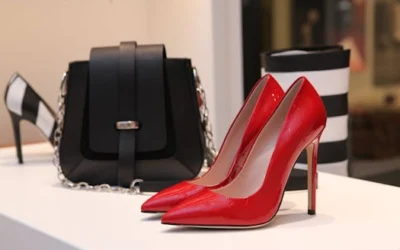 Showcasing sleek red stilettos and a chic black handbag in a luxury boutique setting.