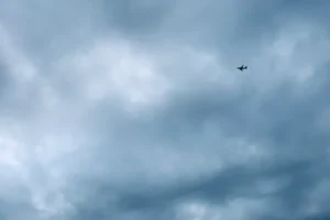 airplane flying under cloudy sky during daytime