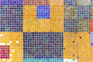a multicolored tiled wall with a blue square in the middle