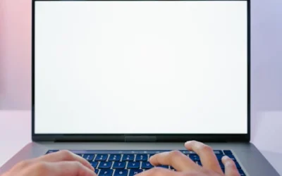 Close-up view of hands typing on a laptop with a blank screen, ideal for design mockups.