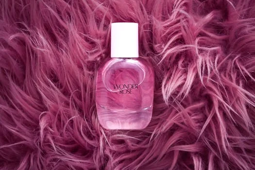 A stylish pink perfume bottle on a plush, pink fur background, exuding elegance and luxury.