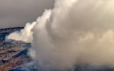 a large plume of smoke coming out of a mountain