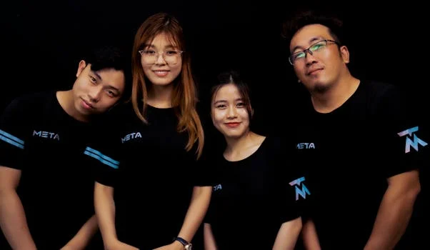 Four diverse young adults in META logo T-shirts against a black background.