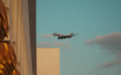 A large jetliner flying over a tall building